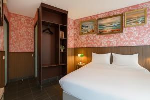 パリにあるWalled off Hotel Parisのピンクの壁紙を用いたベッドルーム1室(大型ベッド1台付)