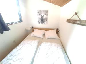 a small bedroom with a bed in a room at Wald Chalet Nr 2 in Kellenhusen