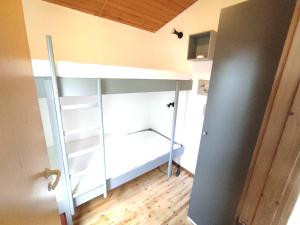 a bedroom with a bunk bed with a ladder at Wald Chalet Nr 2 in Kellenhusen