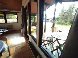 a room with a porch with a table and chairs at Wald Chalet Nr 2 in Kellenhusen +4 photos