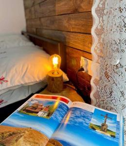 a book sitting on a table next to a bed at Wilczy Domek Cisna in Cisna