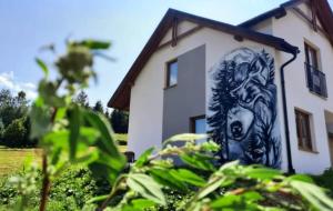 a building with a painting on the side of it at Wilczy Domek Cisna in Cisna +8 photos