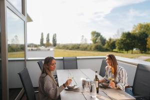 two women sitting at a table with glasses of wine at Kooparc in Giesbeek +39 photos