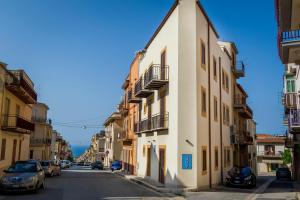 a street with cars parked on the side of a building at Affittacamere Amunì in Castellammare del Golfo
