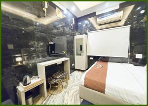 バラナシにあるV - PREMIUM BNR - INN - Free Wi-Fi & Parking - Near The Holy Kashi Vishwanath Templeのベッドとテレビがあるホテルの部屋
