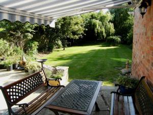 a patio with two benches and a table and a lawn at Bridge House Bed & Breakfast in Newark upon Trent +8 photos