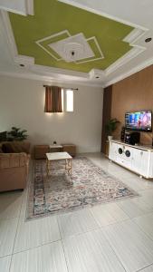 uma sala de estar com teto verde e um tapete em Andhiny homestay em Kejajar