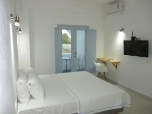 una camera da letto bianca con un letto e un tavolo di Daylight Hotel a Perissa