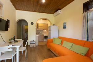 a living room with an orange couch and a kitchen at Zeusplace Kallithea Park near Olympic Beach in Vromerí