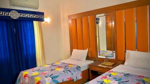 a small room with two beds and a mirror at Hotel Imperial Karachi in Karachi