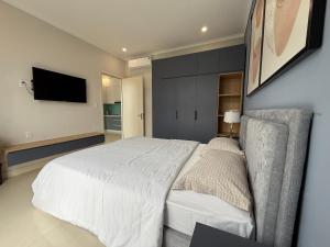 a bedroom with a bed and a tv on the wall at Three women in Phu Quoc