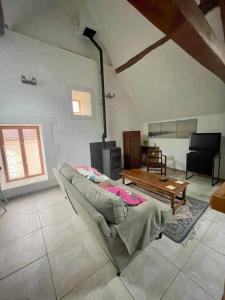 a living room with a couch and a table at loft à la campagne in Vermenton +4 photos