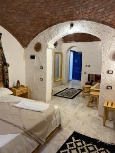 a bedroom with a bed and a brick wall at Bait Gamal Siwa بيت جمال سيوة in Siwa +53 photos
