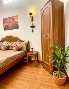 a bedroom with a bed and a potted plant at Hotel Neeraj in Morādābād