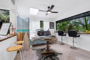 a living room with a couch and a table and chairs at Shellies Twin Beach Houses in Sawtell
