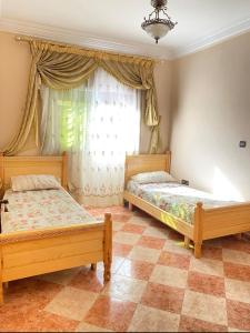 two beds sitting in a room with a window at Family Stay with Lovely View ALhoceima in Al Hoceïma