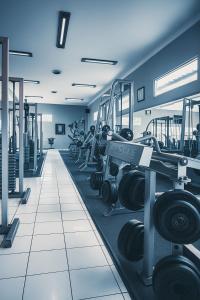 a gym with lots of treadmills and dumbbells at Parkside Mandarin Hotel Pekalongan in Pekalongan +8 photos