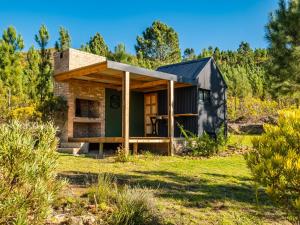 a tiny house in a field with trees at Bumbrah Camp and Glamp in Houhoek