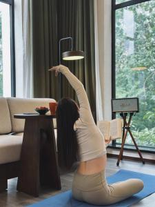 a woman doing a handstand in a living room at Ayata Hotel in Chengdu