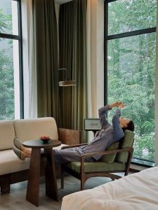 a man sitting on a chair in a living room at Ayata Hotel in Chengdu +120 photos