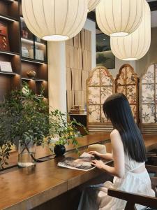 a woman sitting at a table in a store at Ayata Hotel in Chengdu