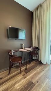a room with a table and chairs and a tv at 4 winds Notus in Palanga
