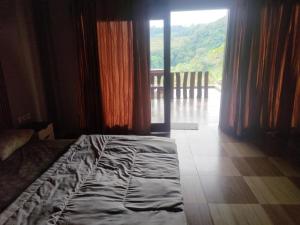a bedroom with a bed and a large window at Senaru Lodge in Senaru +6 photos