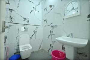 a white bathroom with a sink and a toilet at Ganapathi Sahakara Sadhana in Malpe +12 photos