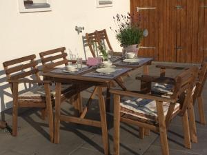 uma mesa de madeira com duas cadeiras e uma mesa e uma mesa e cadeira em B&B Friedau em Nottwil