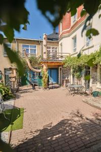 a brick courtyard with a large building with a large tree at Urlaubsloft AUGUST'S Schatzkiste in Marienberg