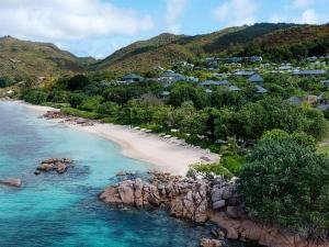 an aerial view of a beach with rocks and houses at Raffles Seychelles in Baie Sainte Anne