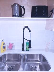 a kitchen sink with a faucet on a counter at Elegant Modern Suite with Comfort & Privacy in Regina +10 photos