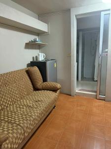 a living room with a couch and a kitchen at Big Moose Pattaya in Ban Nong Chaeng
