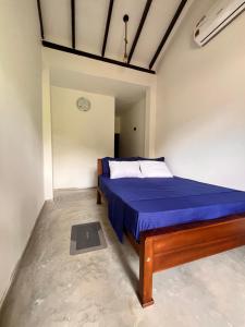 a bedroom with a blue bed in a room at Melon Guest - Weligama in Weligama