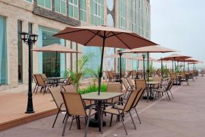 a row of tables and chairs with umbrellas at منتجع صلالة دريم لاند Salalah Dreamland Resort in Salalah