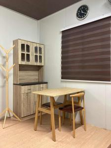 a table and chairs in a room with a clock at Ays homestay in Puerto Princesa City