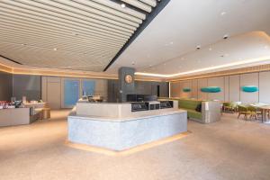 a lobby of a hotel with a counter and tables at JI Hotel Shanghai Caohejing Caobao Road in Shanghai