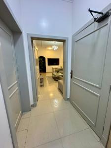 a hallway with a door and a living room at شقق عائلية ثلاث غرف وحمامين وصاله ونت مجاني in Al Ahsa +2 photos