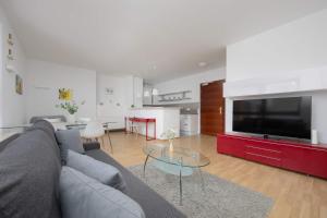 a living room with a couch and a large television at Spacious and Bright Apartment with Parking in the City Center by Noclegi Renters in Warsaw