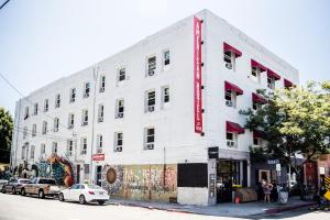 a white building on the corner of a street at American Hotel in Los Angeles