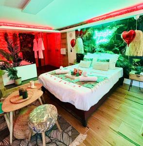 a bedroom with a large bed and a table at Jungle Love avec Balnéo à 10 min de Disneyland Paris in Serris