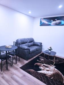 a living room with a couch and two tables at Elegant Modern Suite with Comfort & Privacy in Regina