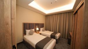a hotel room with two beds and a skylight at بنزرت للشقق الفندقية in Al Hofuf