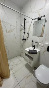 a white bathroom with a sink and a mirror at 4 winds Zephyrus in Palanga +25 photos