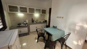a small kitchen with a table and chairs in it at Schonen House by Ruby Living in Yogyakarta