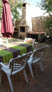 - une terrasse avec une table, 2 chaises et un parasol dans l'établissement Casa Rural Hoces del Duratón El Villar, à Villar de Sobrepeña