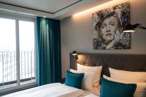 a bedroom with a bed and a large window at Motel One Berlin-Spittelmarkt in Berlin +23 photos