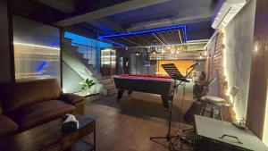 a living room with a pool table and a piano at bonheurhousebetong in Betong