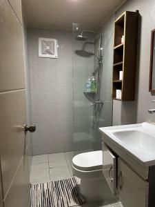a bathroom with a shower and a toilet and a sink at Ina Homestay in Coron +15 photos