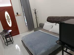 a living room with a bed and a tv at DZ Tiny Home Kota Bharu With Pool, Wifi in Kota Bharu